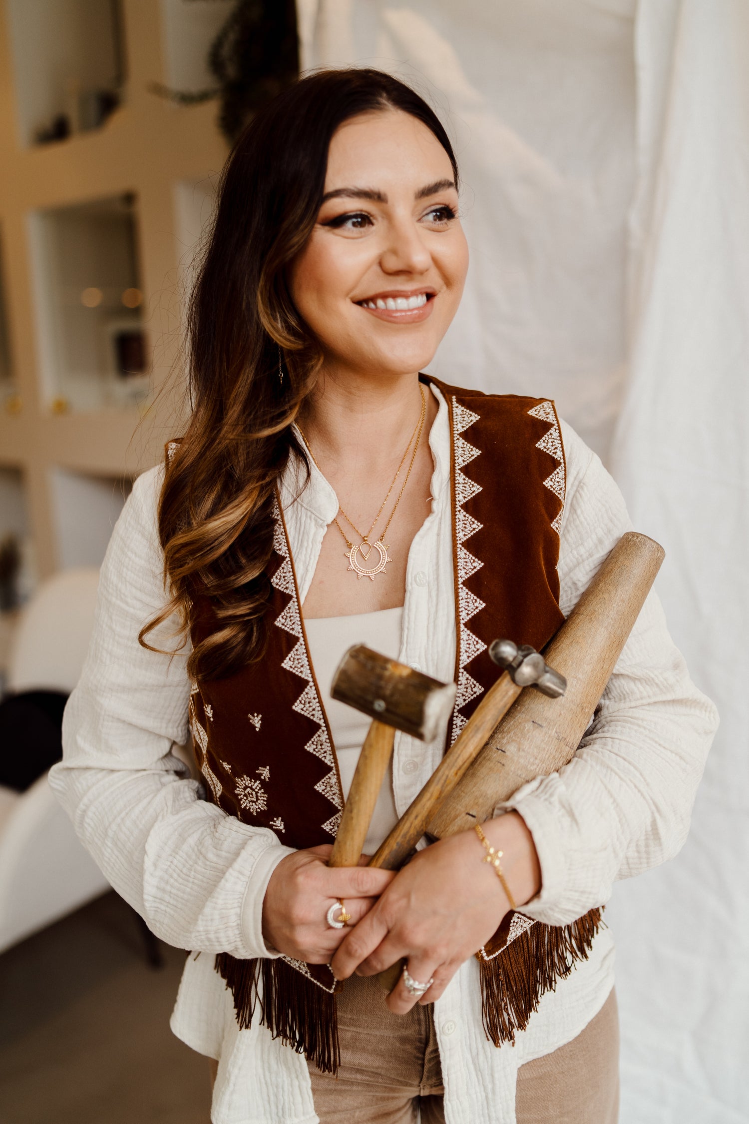 Woman holding tools in a room with shelves and decor
